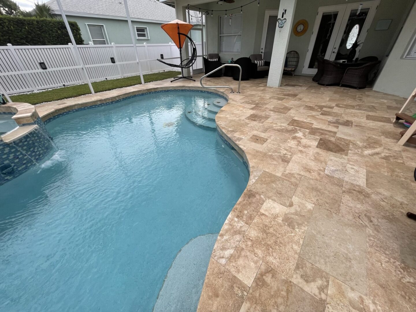 A pool with a tile floor and a deck