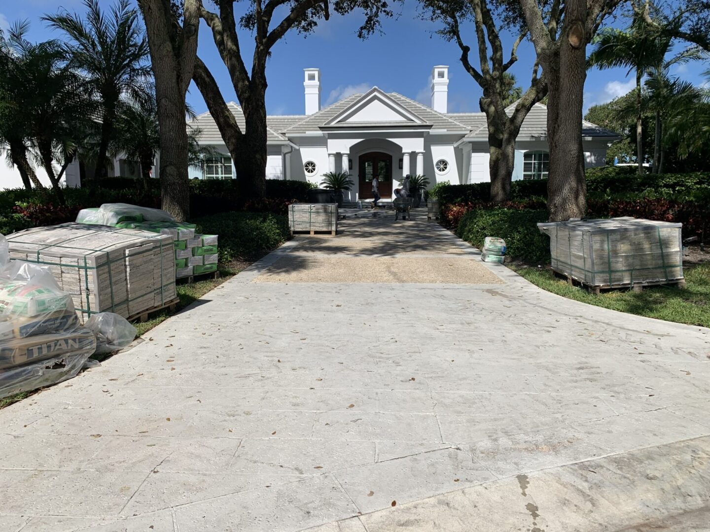 A large white house with trees and a driveway.