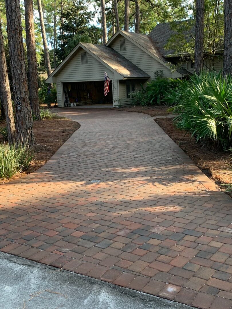 A driveway with brick and concrete in the middle of it.