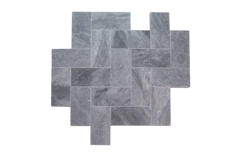 A geometric arrangement of interlocking rectangular gray stone tiles.