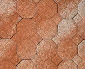 Close-up of a patterned surface featuring octagonal and square terracotta-colored tiles, some lightly dusted with white residue.