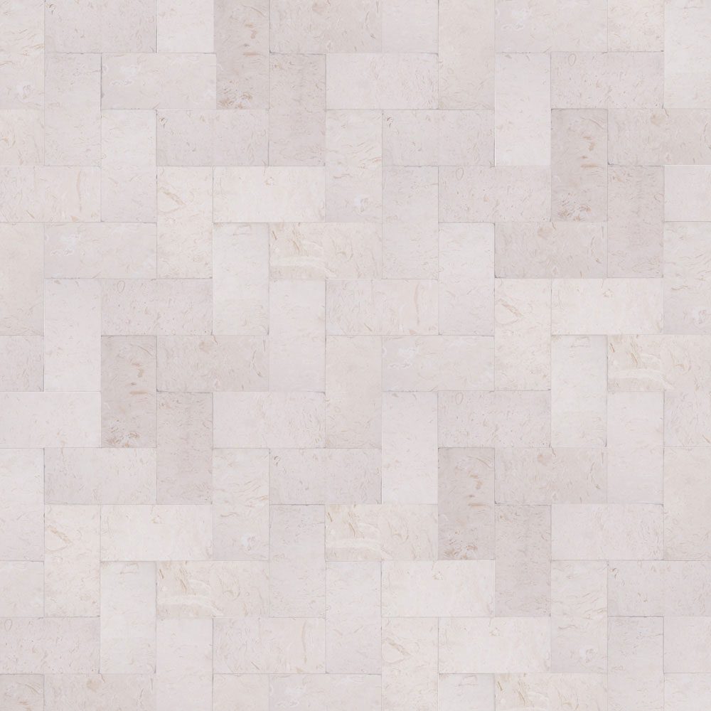 A close-up view of a light-colored, rectangular stone tile pattern arranged in a staggered brick-like formation. The tiles have varied shades of white and subtle textures.