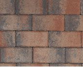 Close-up view of a brick wall with a pattern of reddish-brown and gray bricks.