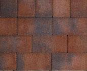 Close-up of a pattern of reddish-brown and grey rectangular roof shingles arranged in a staggered formation.